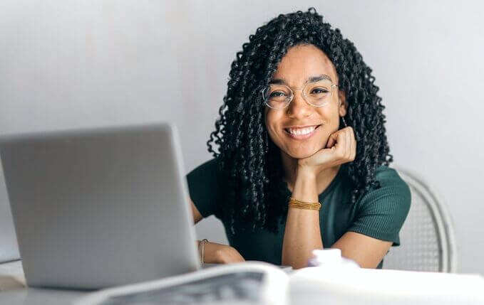 Femme heureuse devant son ordinateur portable Les gestes d'urgences peuvent s'apprendre à distance